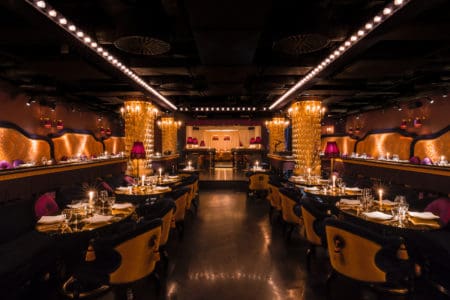 A luxury restaurant venue, decorated in gold with lush seating available for private events