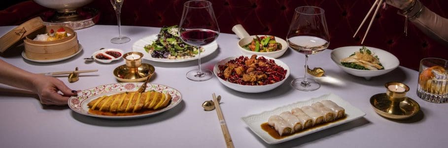 Park Chinois dining table setting filled with Chinese for, Champaign and wine