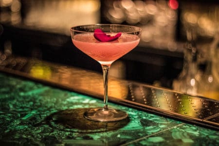 An elegantly poured martini cocktail positioned on Park Chinois marbled bar top