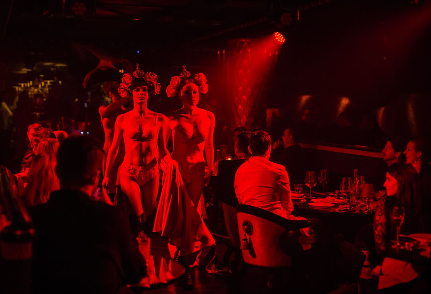 Park Chinois Club Cabaret performance with red lights, dancers and guests dining in Mayfair